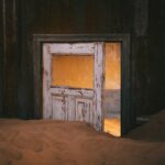 A picture with a door and sand.